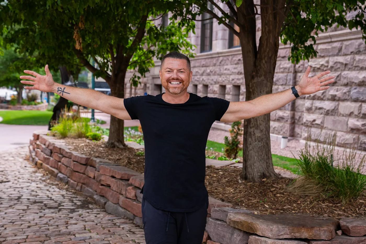 Brian Rand outdoors with arms wide open